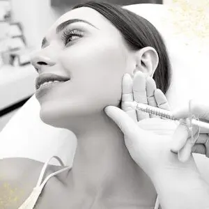 A woman getting her ears pierced by an ear candling.