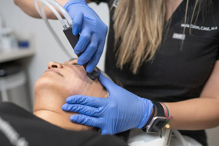 A person getting their face waxed by an esthetician.